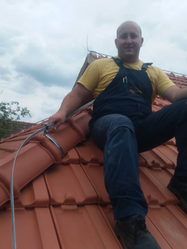Na krovu kuće je čovek Ferenc Menjhart drži gromobran